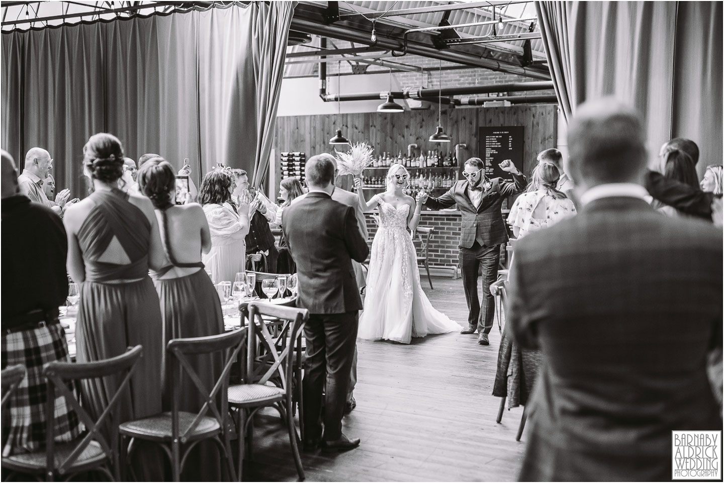 Candid photos of the Entrance of the bride and groom at the Bowers Mill in Halifax by Yorkshire Wedding Photographer Barnaby Aldrick
