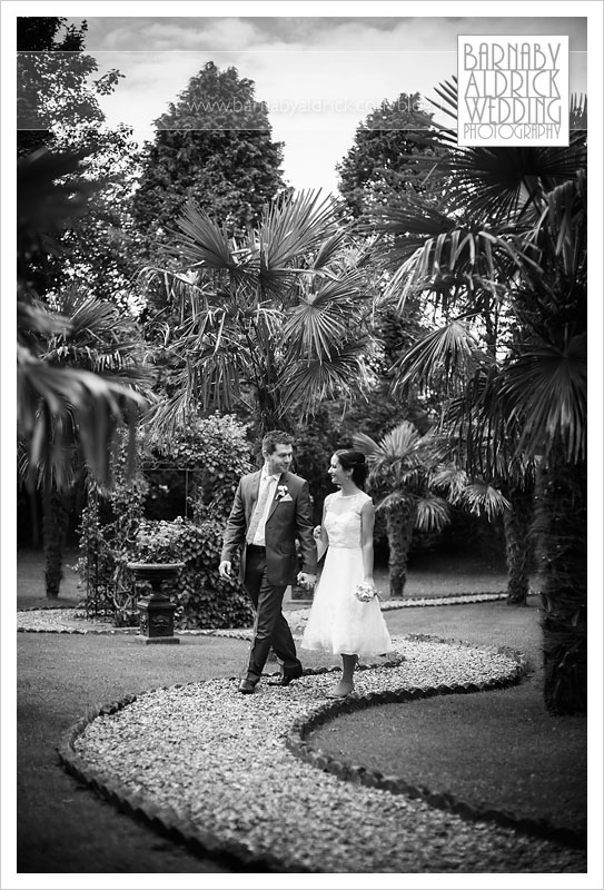 A relaxed portrait of a bride and groom walking around the unusual tropical gardens at the Crab & Lobster boutique wedding venue in Asenby near Thirsk in North Yorkshire