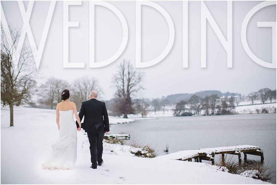 A bride and groom walk around the snowy lake at a stunning winter Yorkshire ancient castle wedding venue called Ripley Castle