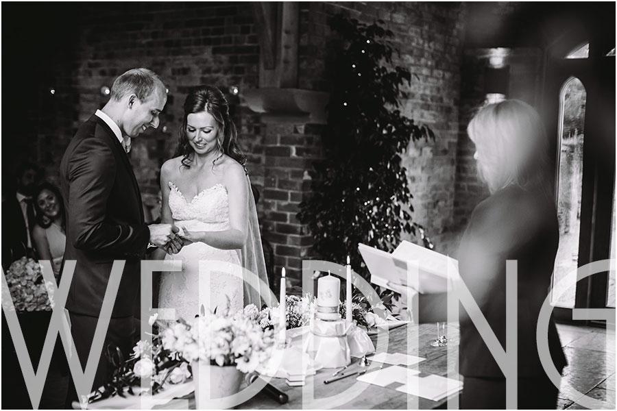 A bride and groom exchange rings during their wedding civil ceremony at Cripps Shustoke Farm Barns Wedding venue near Solihull and Birmingham in the East Midlands