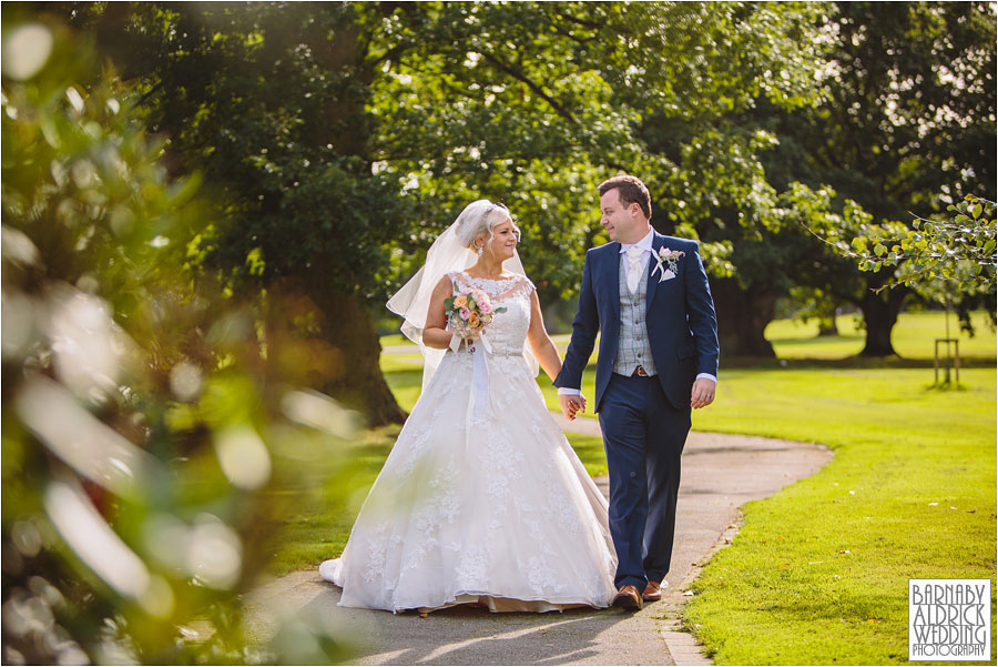 A newlywed bride and groom walk together in the afternoon sunlight after their civil ceremony at the stunning wedding venue Rudding Park near Harrogate in Yorkshire
