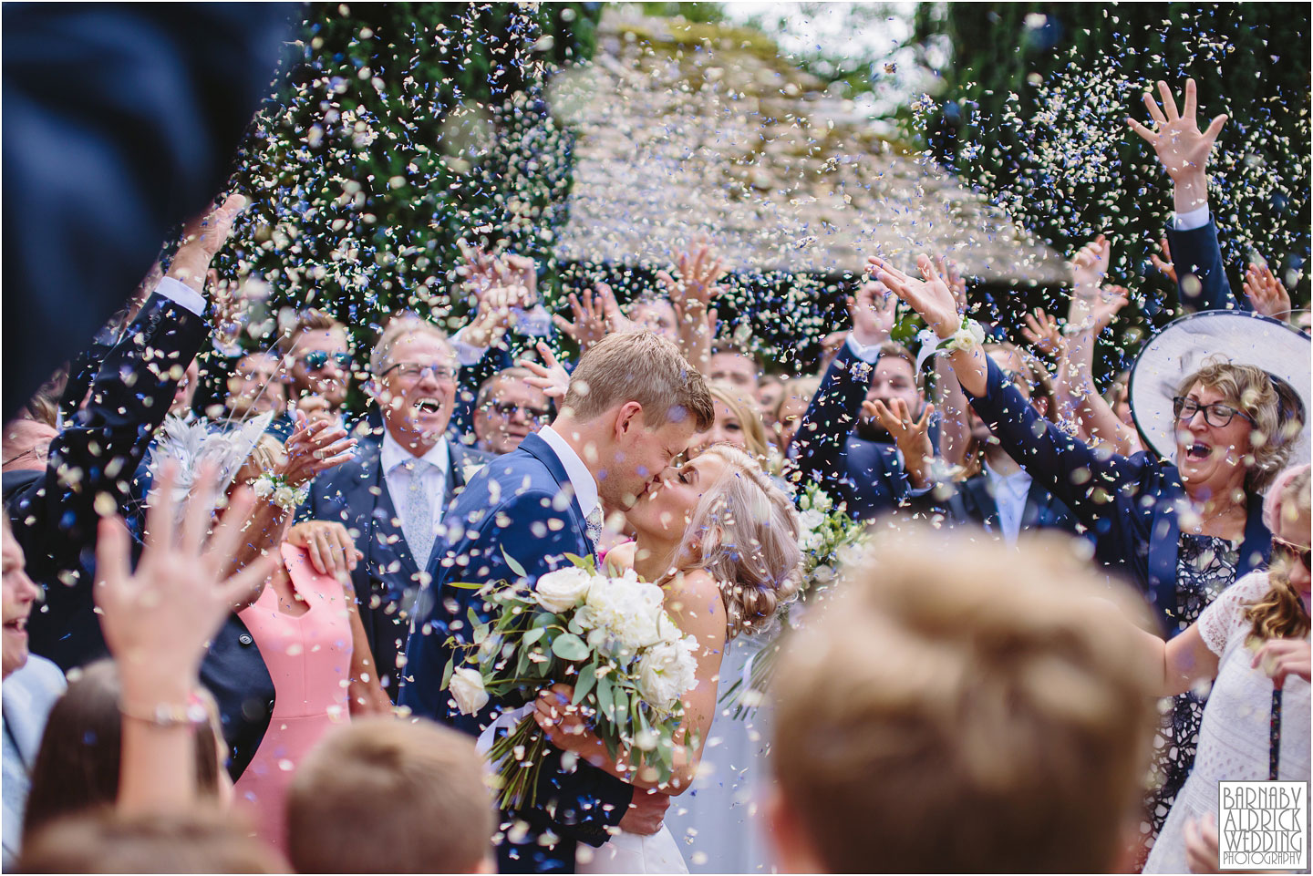 Wedding Couple kissing outside the church in lower slaughter in the cotswolds